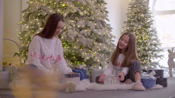 Siostry Rozpakowują Prezenty Siedząc Przy Choince Dziewczyny Dają Sobie Pięć — Wideo stockowe