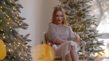 Güzel genç bayan tıbbi maskesini çıkarıp şampanya içiyor. Sarışın kız kutlama sırasında geleneksel Noel şapkasını takıyor. Yüksek kalite 4k görüntü