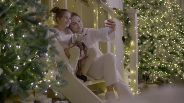 Två Flickor Gör Selfie Med Festlig Juldekoration Bakgrunden Barn Vita — Stockvideo