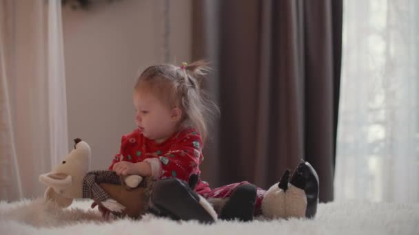 Flickan Leker Med Sina Leksaker Det Vita Sängkläderna Barnet Ser — Stockvideo