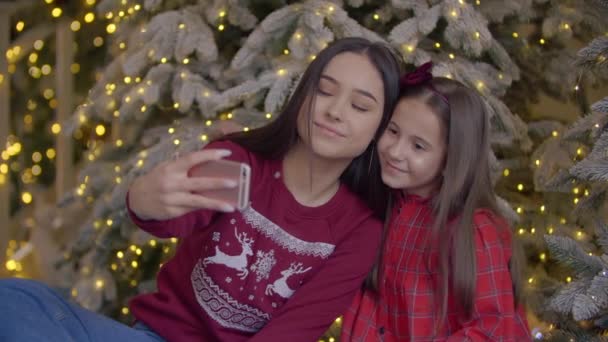 穿着传统红色圣诞毛衣的朋友们都是自拍的 快乐的女孩互相微笑着欣赏着照片 高质量的4K镜头 — 图库视频影像