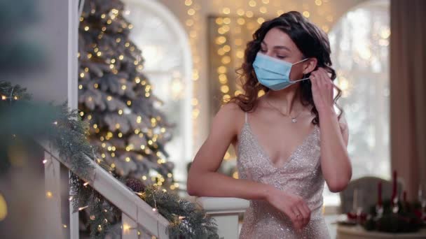 여성은 전염병 유행하는 시기에 크리스마스를 레이디는 의학용 마스크를 버리고 웃는다 — 비디오