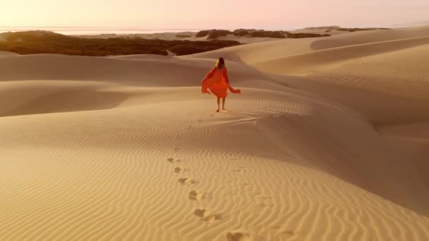 Turuncu Elbiseli Genç Bir Kadın Altın Gün Batımında Kum Tepesinde — Stok video