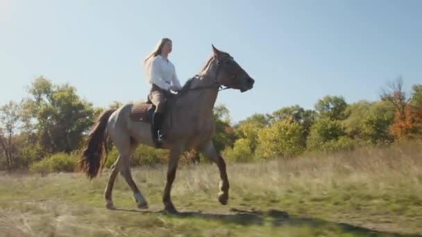 白种人 金发女骑师喜欢骑马绕着色彩斑斓的树叶 马术俱乐部里漂亮活跃的女人高质量的4K镜头 — 图库视频影像