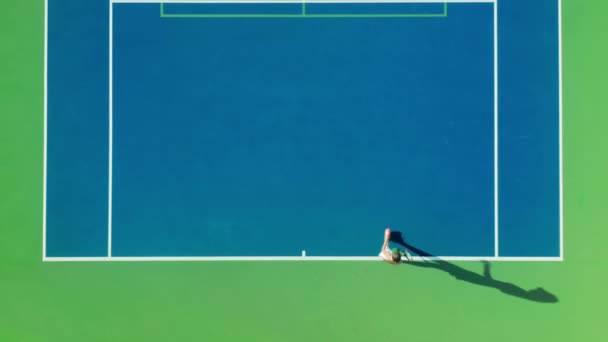 一名女运动员在训练期间的4K航拍自上而下的照片 阳光灿烂的日子里 一个女的在打网球 长长的阴影在快速移动 在地面上显示出人类的青少年形象 — 图库视频影像