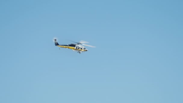 在洛杉矶郊区的好莱坞山上 在野火之上飞行的消防直升机的戏剧性景象 洛杉矶县消防部门的直升机在晴朗的蓝天中飞行 消防直升机灭火 — 图库视频影像
