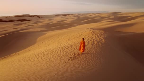 Zeitlupe Drohne Fliegt Frau Orangefarbenem Kleid Auf Sanddünen Bei Goldenem — Stockvideo