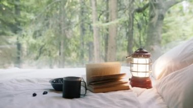 Hareketli arka planda büyülü orman ile kırmızı antik fener sihirli ışık altında açılan kitabın RED kamerasına yakın çekim yavaş çekim. Doğa Manzarası Arkaplanı, 4K kırsalında hafta sonu.