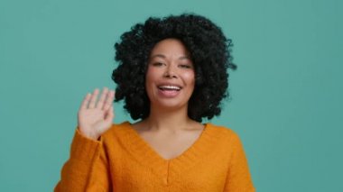Genç mutlu Afrikalı Amerikalı karışık ırk hipster vlogger kadın el sallayarak web kamerasına bakıyor izole edilmiş arka planda kameraya konuşuyor sosyal mesafe arkadaşıyla sanal sohbet görüşmesi çağrısında bulunuyor.