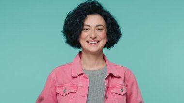 Kameraya bakan 40 'lı yaşlarda, çekici ve gülümseyen bir kadının portresi. Kıvırcık saçlı, kendine güvenen bir kadın. Çekici bir kadın ağır çekimde gülümsüyor.