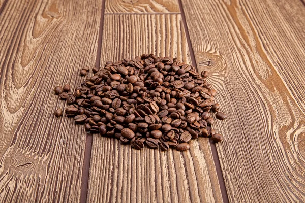 Coffee beans on wooden table — Stock Photo, Image