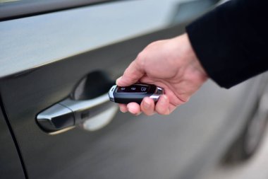 Uzaktan kumandalı araba alarmına kadın el basıyor