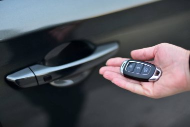 Bir kadın elinde bir arabanın anahtarını tutuyor.