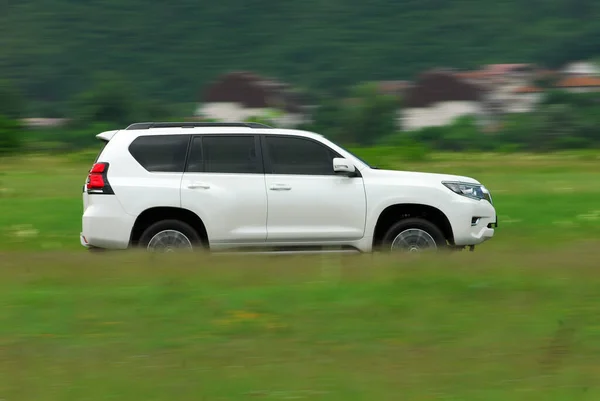 White Suv Drives Fast Grass — Stock fotografie