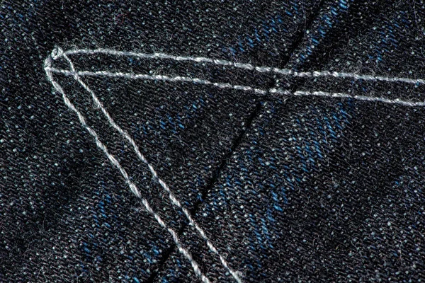 Тёмно-синие джинсы в джинсах со швами и швом на фоне текстуры . — стоковое фото