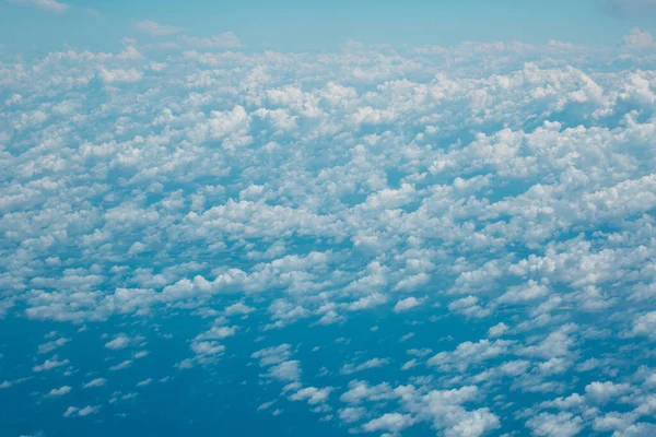 Şehri, tarlaları, denizi ve bulutları gören bir uçağın penceresinden. Gökyüzünde uçan kanatları görüyor musun?