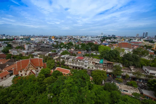 Wide angle view from a bird\'s eye view of the old city of Bangkok, Wat Phukhao Thong in the background is a tall building in the business district of Silom, Sathorn.