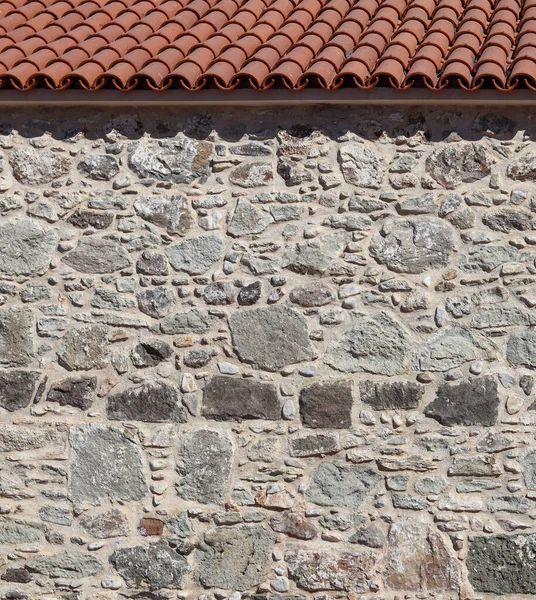 Часть старой каменной стены и крыши. Естественный фон или текстура — стоковое фото
