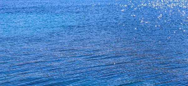 Mer bleue sous la lueur du soleil comme fond de surface. Concept vacances d'été — Photo