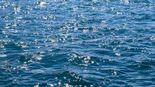 Blauwe zee golven in zonneschijn gloeien als oppervlakte achtergrond. Begrip zomervakantie — Stockfoto