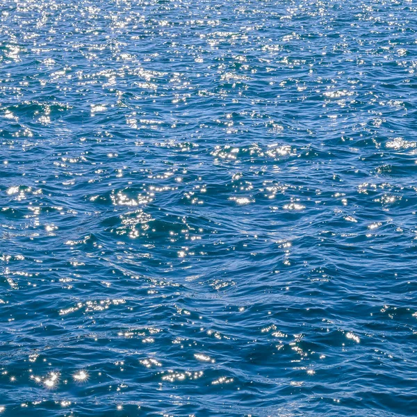 Blauwe zee golven in zonneschijn gloeien als oppervlakte achtergrond. Begrip zomervakantie — Stockfoto