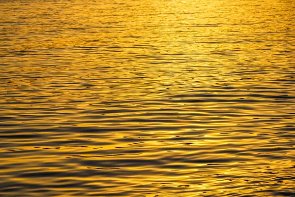 Vagues de mer dorées dans la lueur du coucher du soleil comme fond de surface. Concept vacances d'été — Photo