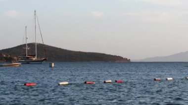 Mavi deniz, adalar, dağlar ve tekneler. Deniz manzarası ve kıyı doğası kavramı
