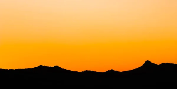 Background from a beautiful colorful sunset with the silhouette of the mountains — Stock Photo, Image