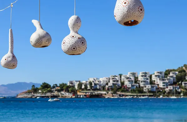 Deniz kıyısının arka planında el yapımı kabak kabağı lambaları. Yaz tatili ve seyahat konsepti Telifsiz Stok Fotoğraflar