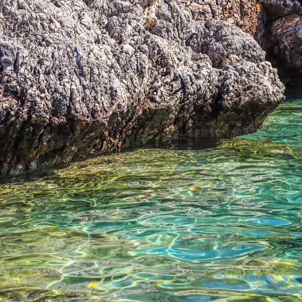 Zümrüt deniz suyu ve doğal kayalık deniz kıyısı. Yaz tatili ve kıyı doğası kavramı