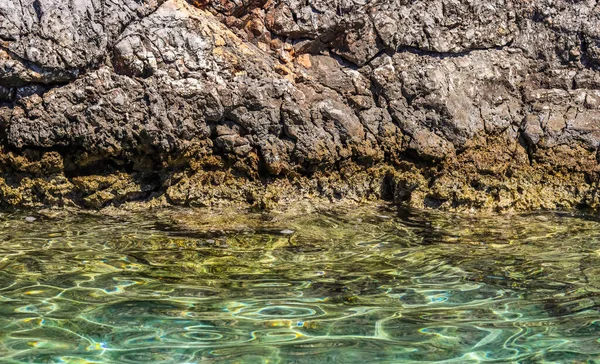 Smaragdgrünes Meerwasser und natürliche felsige Meeresküste. Sommerurlaub und Küstennaturkonzept — Stockfoto