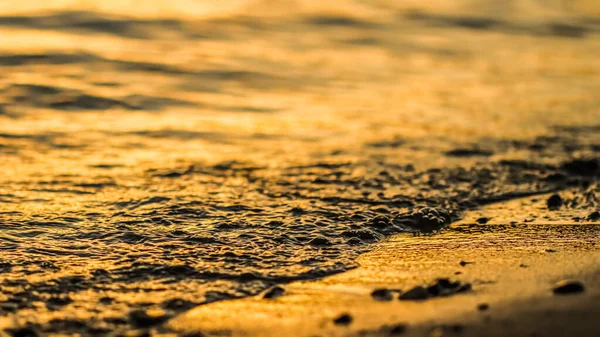 Vague qui coule sur la plage de sable au coucher du soleil. Vacances d'été fond — Photo