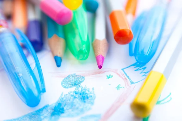 Colored pencils and child's drawing — Stock Photo, Image