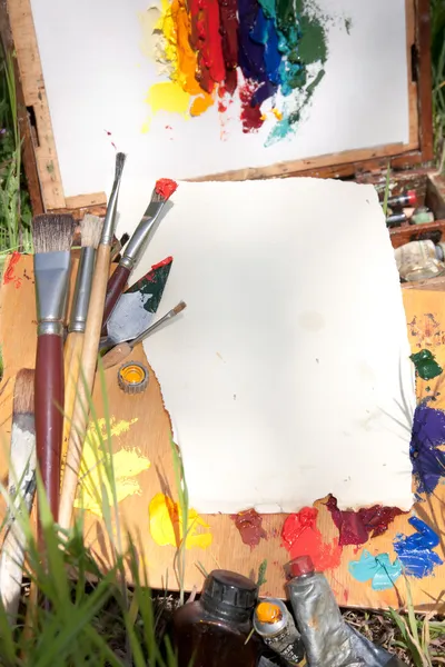 Używaj szorstkiego papieru na palecie leżącego w sprawie malarz na trawie — Zdjęcie stockowe