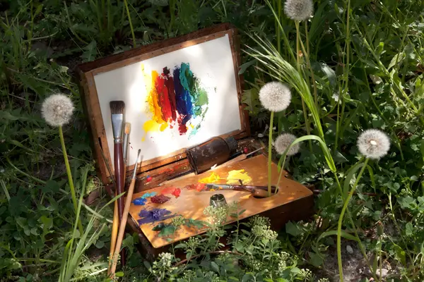 Caja de pintor vintage compacto sobre hierba con paleta y herramientas artísticas —  Fotos de Stock
