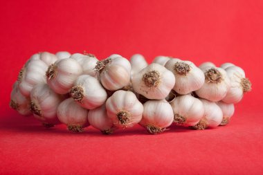 parlak kırmızı bir arka plan üzerine sarımsak demet