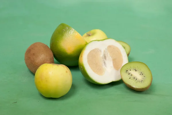 Oroblanco and other green fruits on a green background — Stock Photo, Image