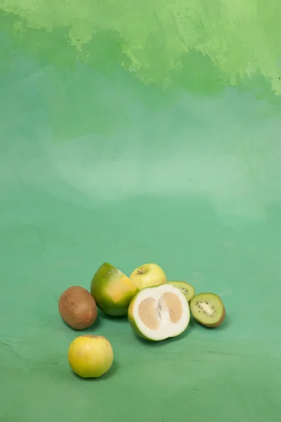 Oroblanco e outras frutas verdes em um fundo verde — Fotografia de Stock