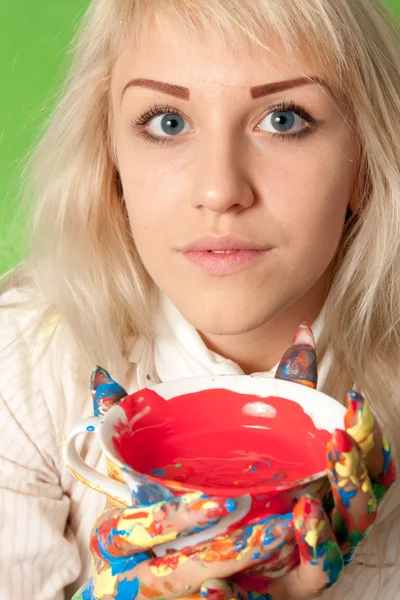 Portrait d'une jolie fille aux mains colorées une tasse de peinture rouge — Photo