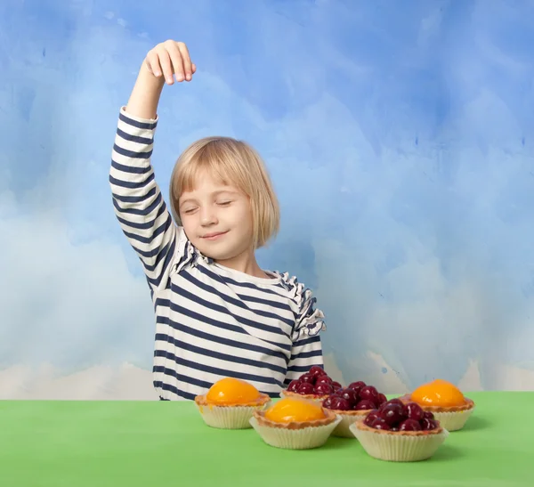 Kleines Mädchen tanzt hinter Kirsch- und Pfirsichgelee-Torten — Stockfoto