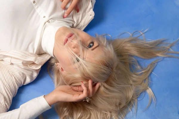 Portrait d'une jolie jeune femme sur fond bleu — Photo