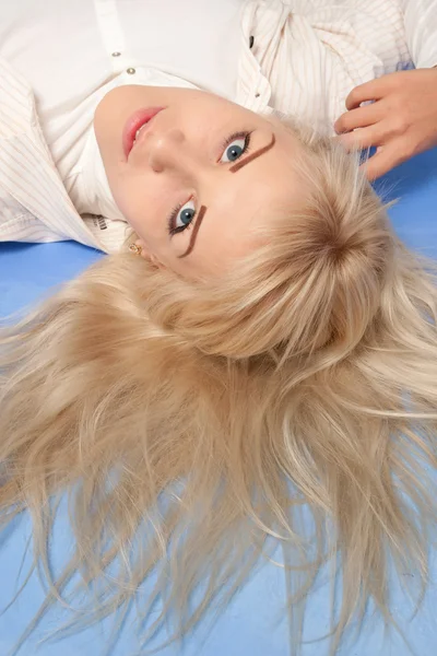 Retrato de una joven atractiva sobre un fondo azul — Foto de Stock