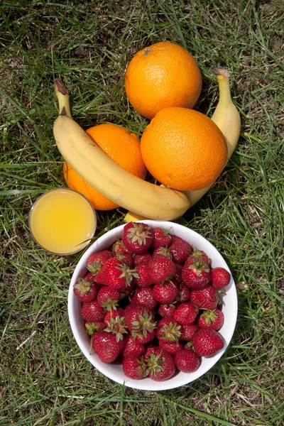Strawberries, oranges, bananas, apple and a glass of orange juice — Stock Photo, Image
