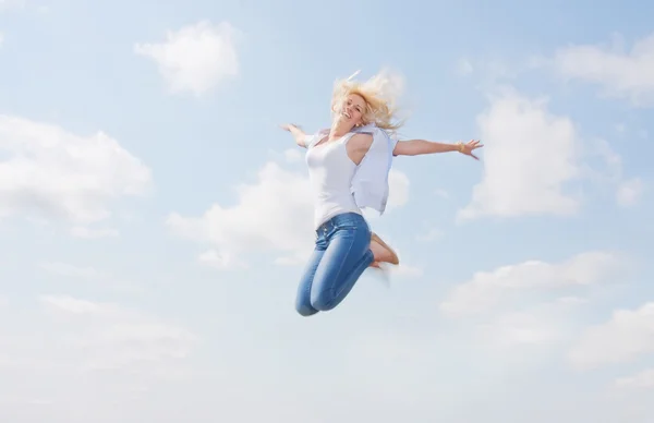 Schöne Blondine fliegt in den Wolken — Stockfoto