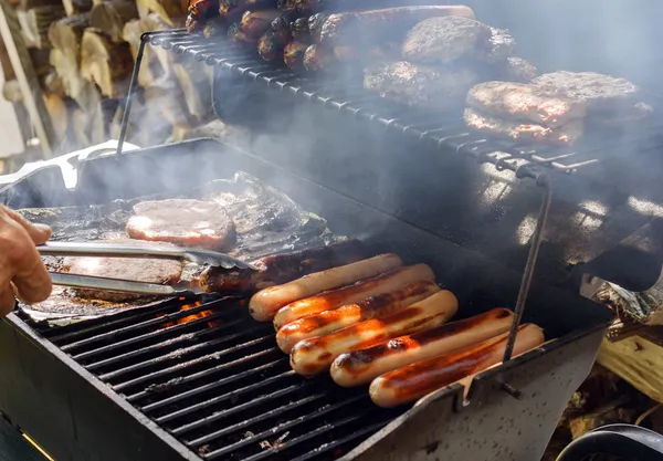 Hotdogs en hamburgers op de grill — Stockfoto