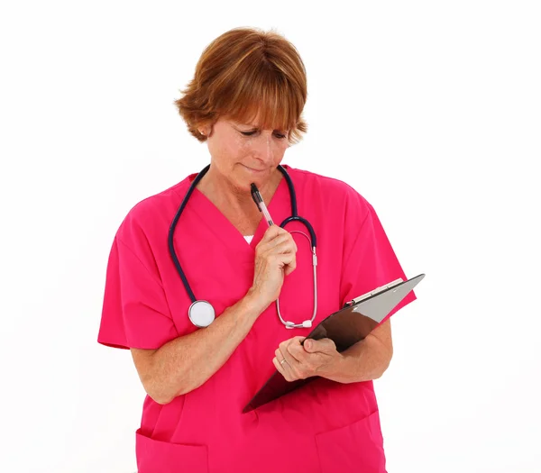Krankenschwester denkt beim Blick auf Diagramm — Stockfoto