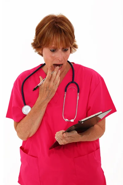 Krankenschwester macht überraschtes Gesicht am Klemmbrett — Stockfoto