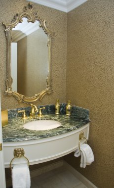 Mermer lavabo ve baget çerçeveli ayna üzerinde pirinç musluk