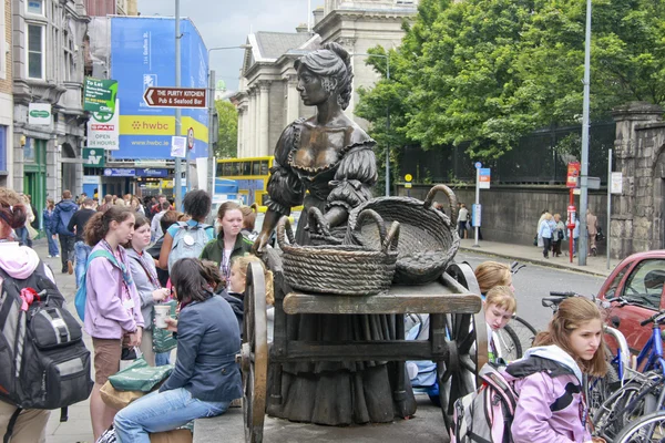 La estatua de Molly Malone a lo largo de Grafton Street frente al Trinity College Dublín rodeado de estudiantes —  Fotos de Stock