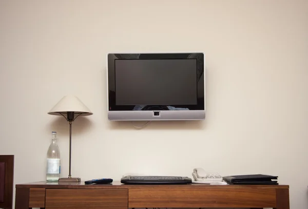 Study room with writing desk keyboard phone lamp and lcd tv set — Stock Photo, Image